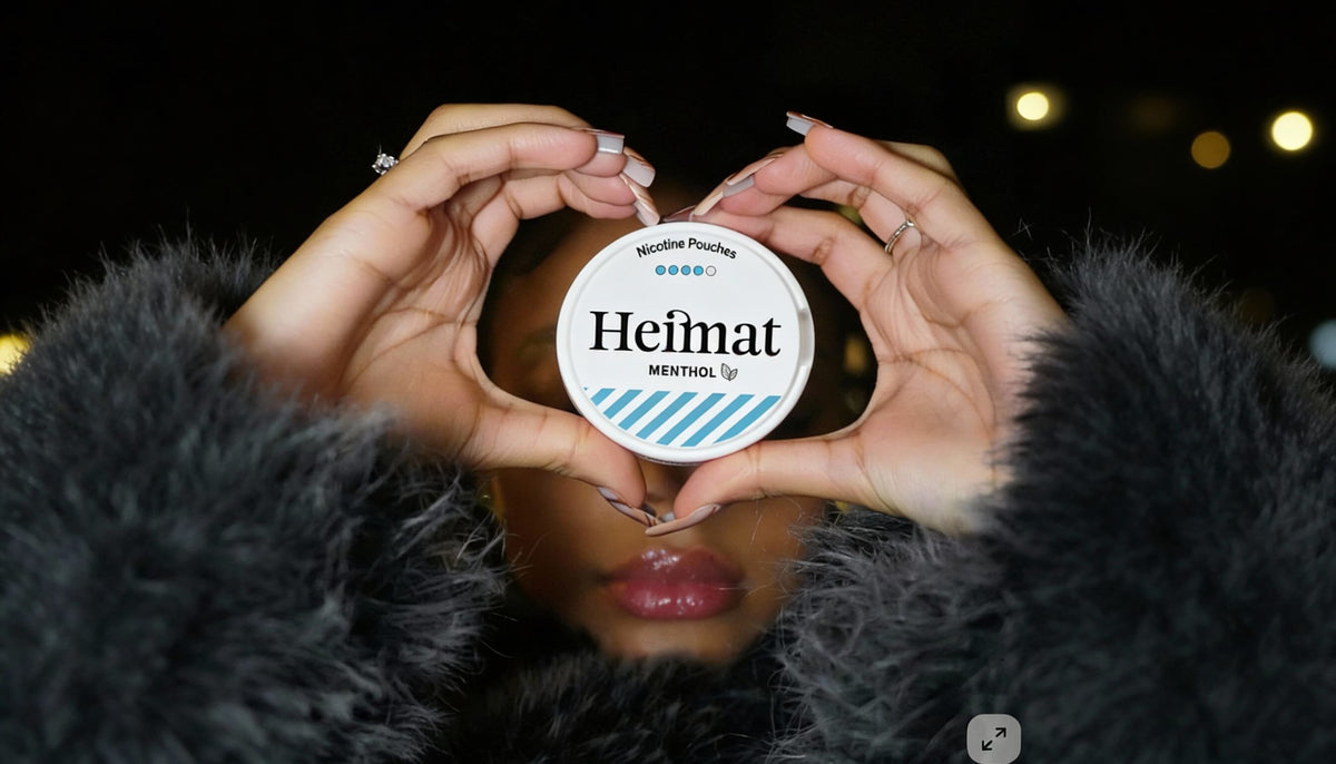 Doză de Heimat Menthol Nicotine Pouches în formă de inimă ținută în mână, fotografie lifestyle cu o femeie în palton negru